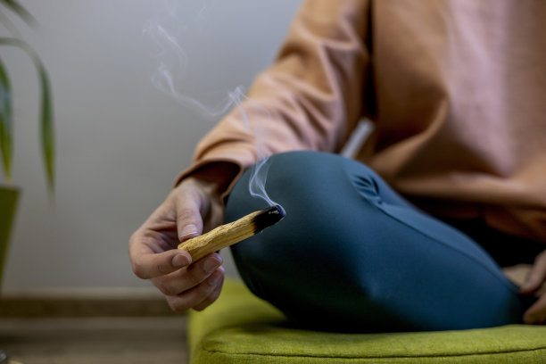 小女孩坐成莲花姿势，双手捧着Palo Santo。香的气味。图片下载