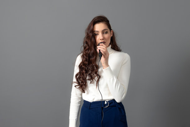 有吸引力的女会议发言人在演示期间，拿着麦克风，做一些手势图片下载