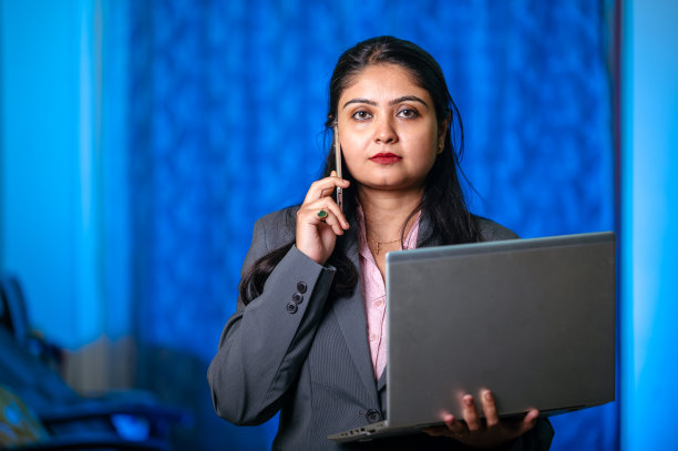 美丽的女商人使用笔记本电脑和智能手机在办公室图片下载