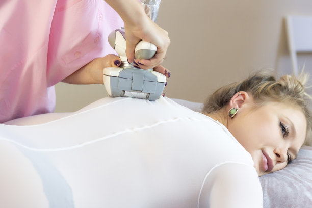 美丽的女人用液化石油气机器在她屁股上对脂肪团进行美容治疗。液化石油气按摩提升身体图片下载