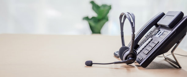 通信支持，呼叫中心和客户服务帮助台。办公室电话设备与VOIP耳机。客户服务支持(呼叫中心)概念。图片下载