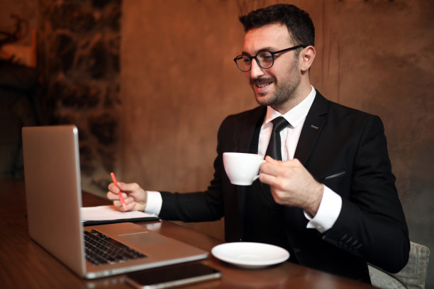 年轻的商人喝着咖啡，工作在金融和加密货币和在线会议图片下载