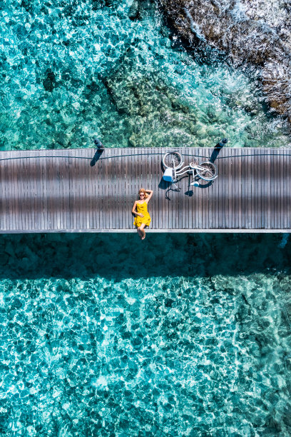美丽的女人躺在码头与自行车在马尔代夫图片下载