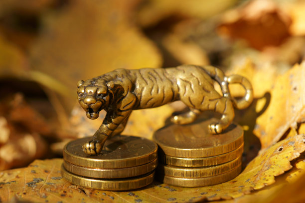 以秋叶为背景的金属老虎铜像。图片下载