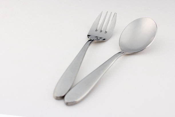 银勺子和叉子由钢和不锈钢放在白色的背景上。图片下载