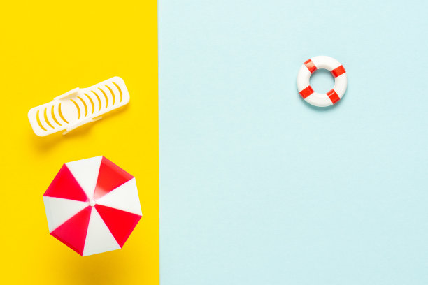 夏日沙滩风光，配有遮阳伞和日光浴床。最小的夏天背景。图片下载