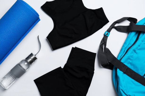 瑜伽垫，时尚的运动服和瓶装水在白色的背景，平躺图片下载