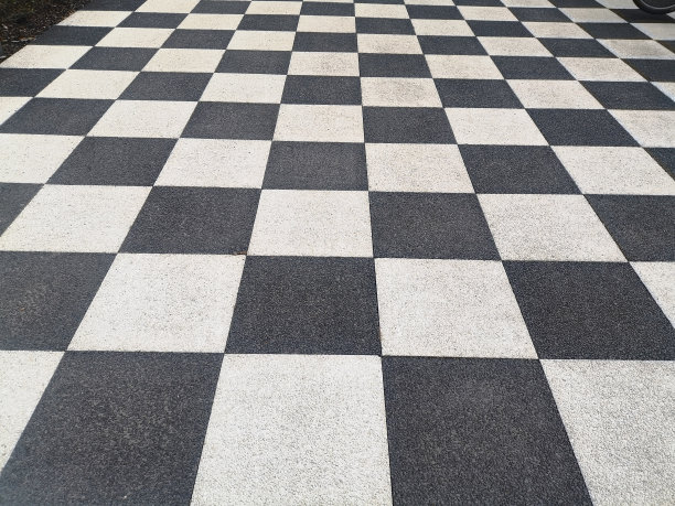 棋盘图案表面，黑色和白色。粒状沥青路面。特写，俯视图，全帧。图片下载