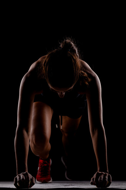 侧面灯光剪影适合女孩在比赛开始位置对黑暗的背景..图片下载