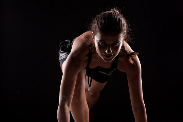 侧面灯光剪影适合女孩在比赛开始位置对黑暗的背景..图片下载