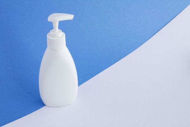 白色塑料分配器在彩色背景上。特写镜头。副本的空间。图片下载