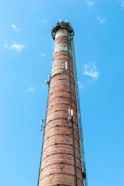 蓝色的天空衬托着旧砖厂的管子。图片下载