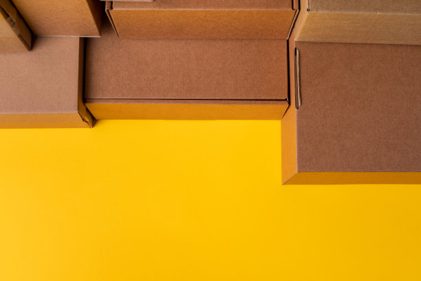 米色纸板盒在黄色背景，关闭图片下载