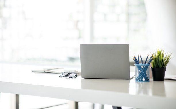 木制办公桌和电脑在办公室工作空间与模拟笔记本电脑设备，工作空间的概念。图片下载