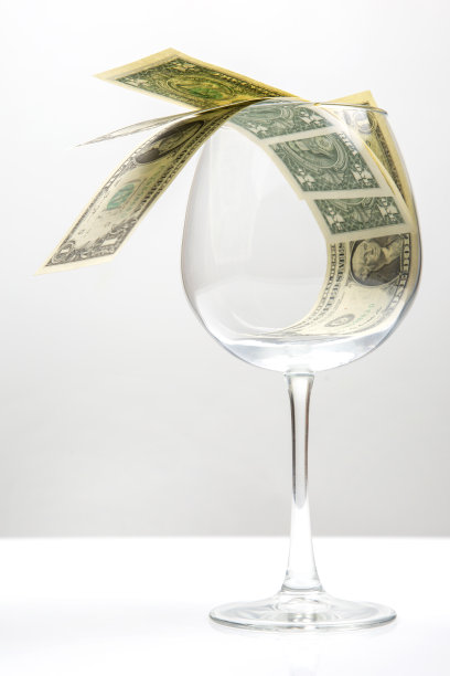一张美元钞票躺在一个空酒杯里。葡萄酒行业的业务。酒精营销图片下载