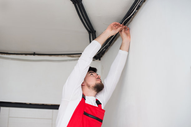 建筑工人修理工正在天花板上安装电线图片下载
