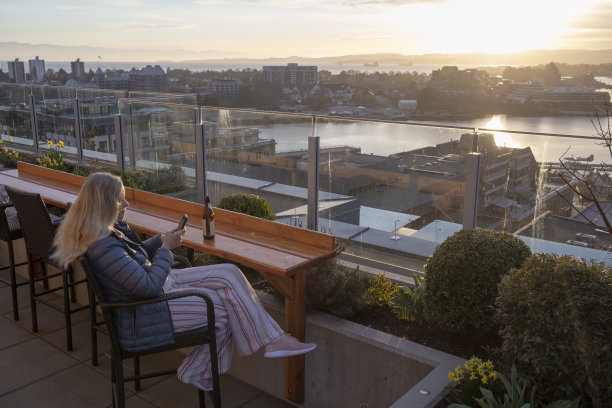 一个女人在屋顶上放松，喝着啤酒图片下载