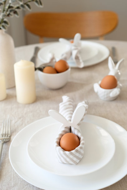 复活节餐桌设置彩蛋复活节兔子餐巾在盘子上。复活节表服务。图片下载