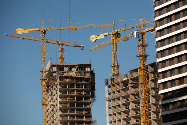 工程和发展。建筑起重机和未完工的高楼大厦。现代城市建筑。图片下载