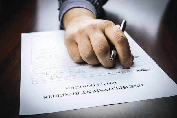 一个人提交社会保障福利申请表的特写。新冠病毒概念和居家秩序对经济、世界经济危机、失业的影响。图片下载