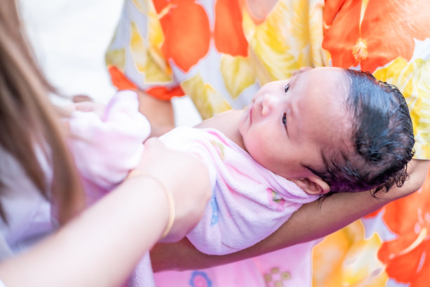 亚洲妈妈沐浴宝宝清洁污垢给宝宝洗澡容器清洁生活方式家庭之间的母亲和孩子之间用于婴儿沐浴露产品，洗发水和婴儿护理产品图片下载