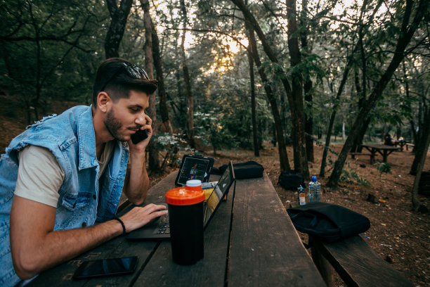 商人在森林办公室用笔记本电脑给客户服务打电话图片下载