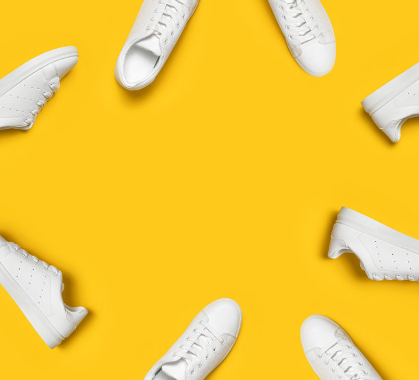 白色妇女的皮革运动鞋在黄色的背景平躺模式。时尚的青年运动鞋、运动鞋、真皮皮鞋。简约的鞋店广告时尚风格鞋的背景图片下载