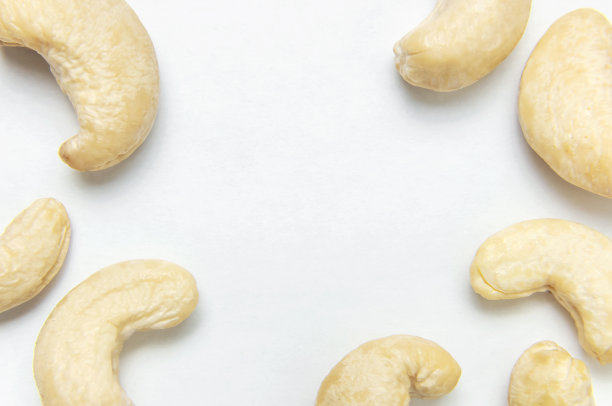 创新食品布局。腰果在白色背景顶视图复制空间。食品概念，健康营养，坚果，健康脂肪。平的。腰果的模式。有机健康的素食小吃微距镜头图片下载