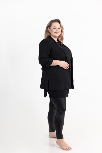 微笑迷人的中年胖胖丰满的女人的肖像长黑发化妆穿黑色开襟羊毛衫。图片下载