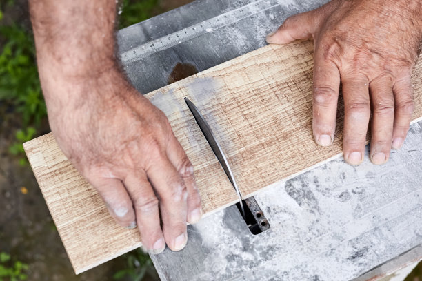 一名男子用水冷的瓷砖切割器切割瓷砖。特写,有选择性的重点图片下载