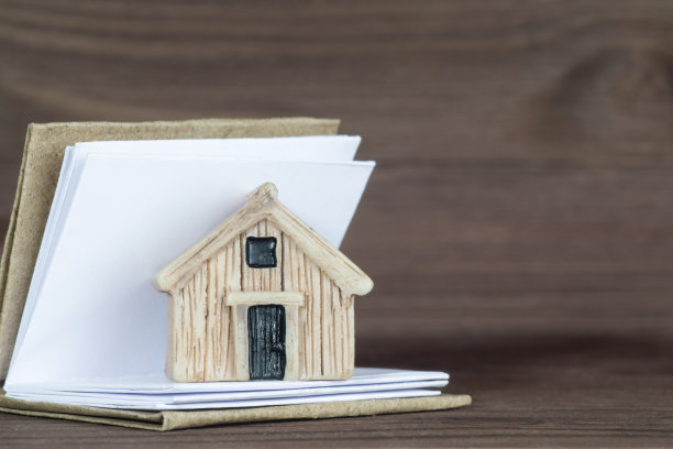 房子模型里面一个打开的书在木桌上图片下载
