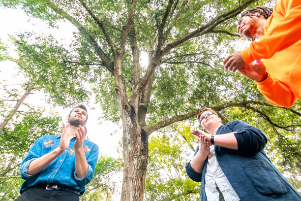 各种各样快乐的年轻人在户外欢笑、鼓掌、唱歌，青年团或俱乐部或团队建设图片下载