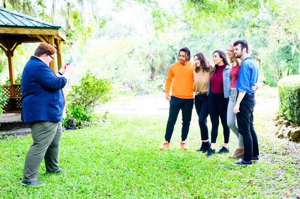 一名男子正在给一群快乐的多样化的朋友拍照，他们是大学生，z一代年轻人，在一起图片下载