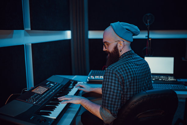 年轻的音乐制作人在录音棚中使用均衡器和混音器图片下载