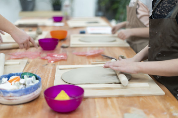 一个孩子在陶瓷教室里制作手工陶瓷的特写，复制空间图片下载