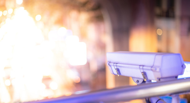 墙上挂着现代化的闭路电视摄像机。模糊的夜景背景。图片下载