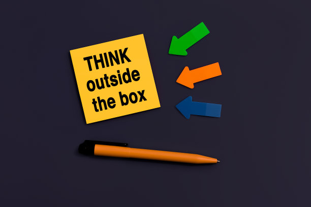 跳出便签上文字的框框。经营理念。橙色方块便签，钢笔和深蓝色背景上的彩色箭头，俯视图图片下载