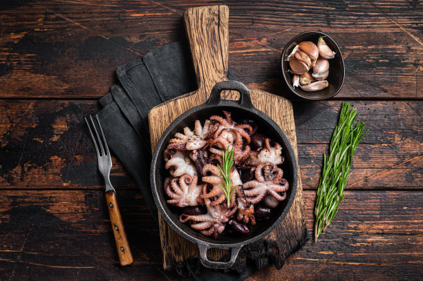 煎章鱼宝宝，加香草。木制背景。俯视图图片下载