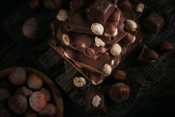 黑背景上的榛子牛奶巧克力和坚果图片下载