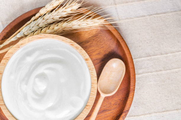 木碗里放希腊酸奶，桌布上放干大麦。图片下载