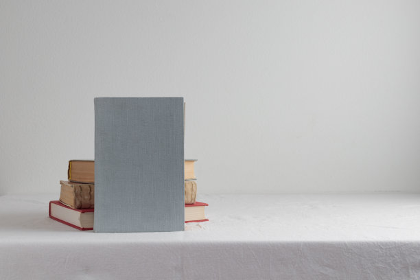 白色的桌子上放着一堆质朴的旧书图片下载