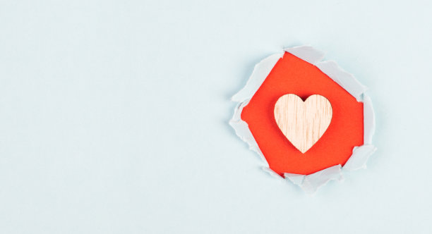 木制的心在红色和浅蓝色的背景，撕纸，节日背景，情人节，友谊，爱和慈善的象征图片下载
