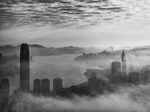 在日出下的雾中，香港市中心的摩天大楼图片下载