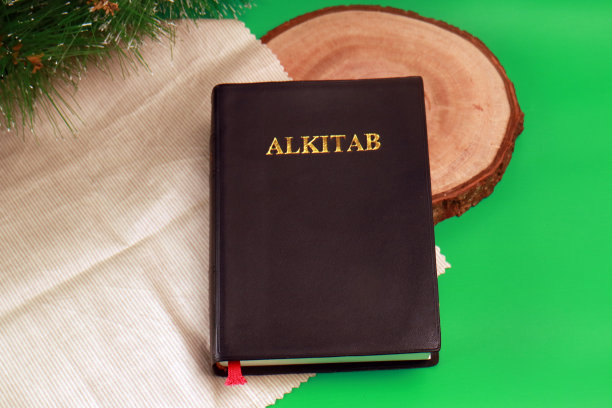 圣经印尼语Alkitab在木板和浅棕色薄布绿色背景图片下载