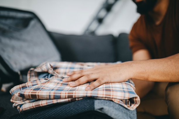 一个年轻的黑人迅速地准备他的旅行箱图片下载