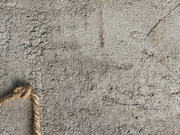 棕色麻绳挂在钉子上，挂在粗糙的水泥墙上。真实的皱纹图案具体纹理背景。图片下载