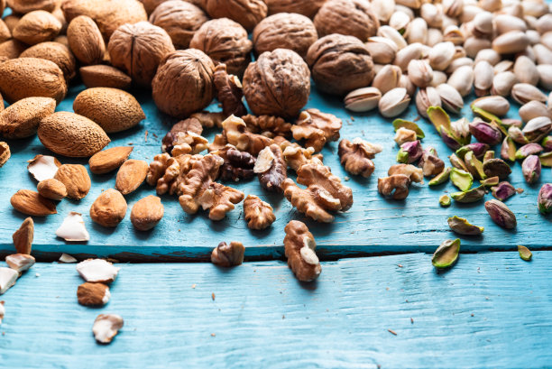 一堆干果，有机的，刚收获的开心果，杏仁，核桃，放在市场的木头上。图片下载