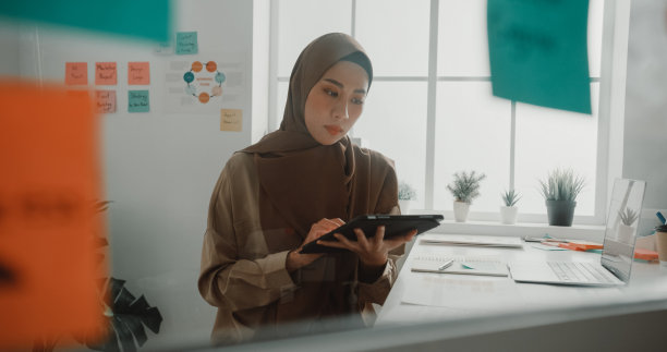 年轻亚洲穆斯林女商人戴头巾在办公室办公图片下载