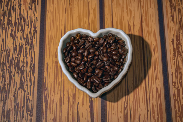 心形白色碗里的咖啡豆图片下载