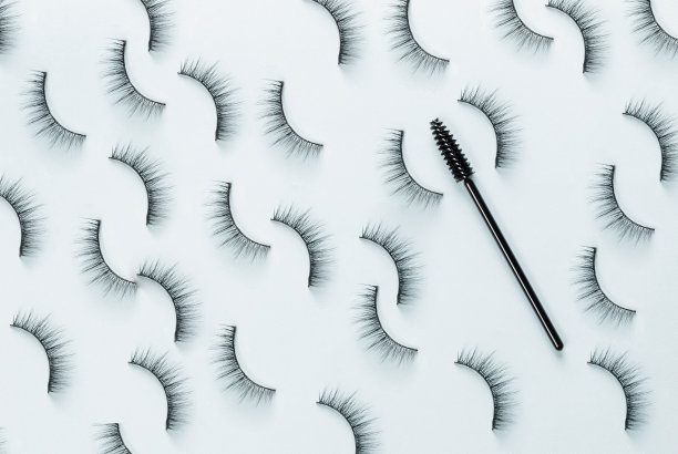 头顶上的睫毛和蓝色背景的画笔。图片下载